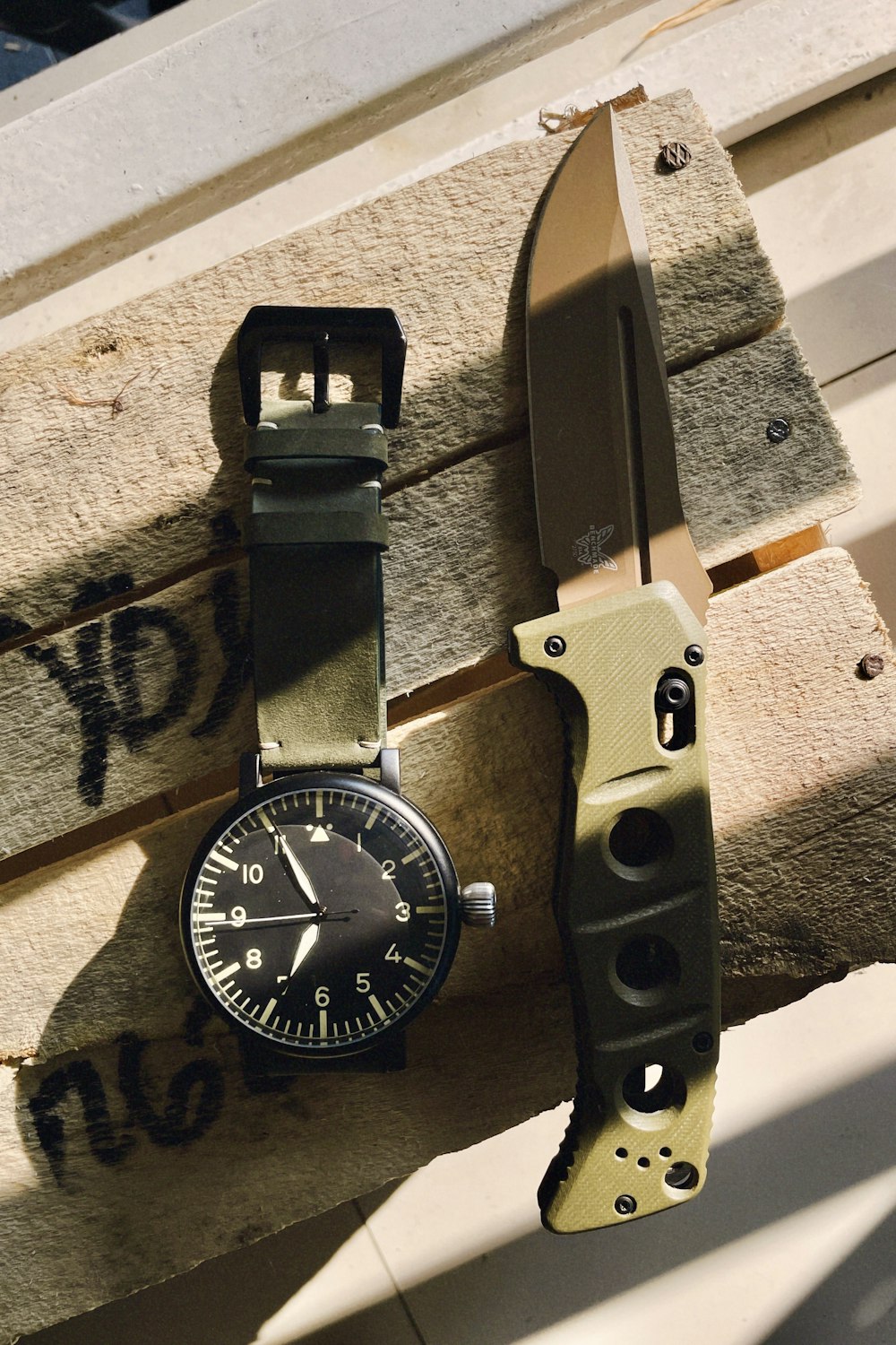a watch and a knife hanging on a wall