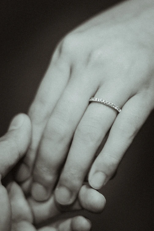 a black and white photo of a couple holding hands