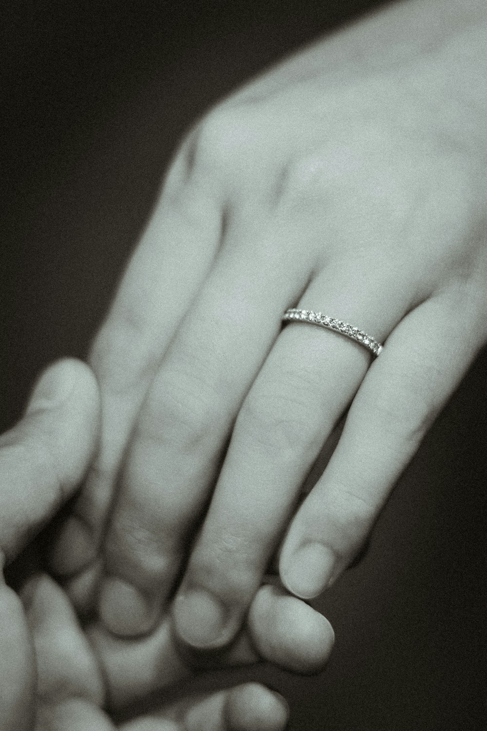 a black and white photo of a couple holding hands