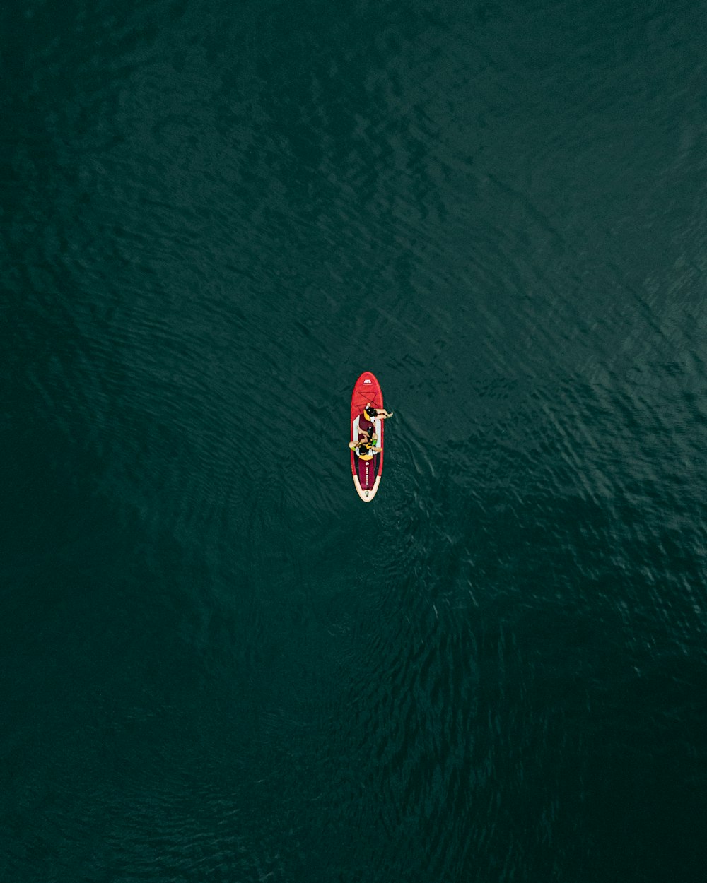 a person in a red kayak in the middle of a body of water