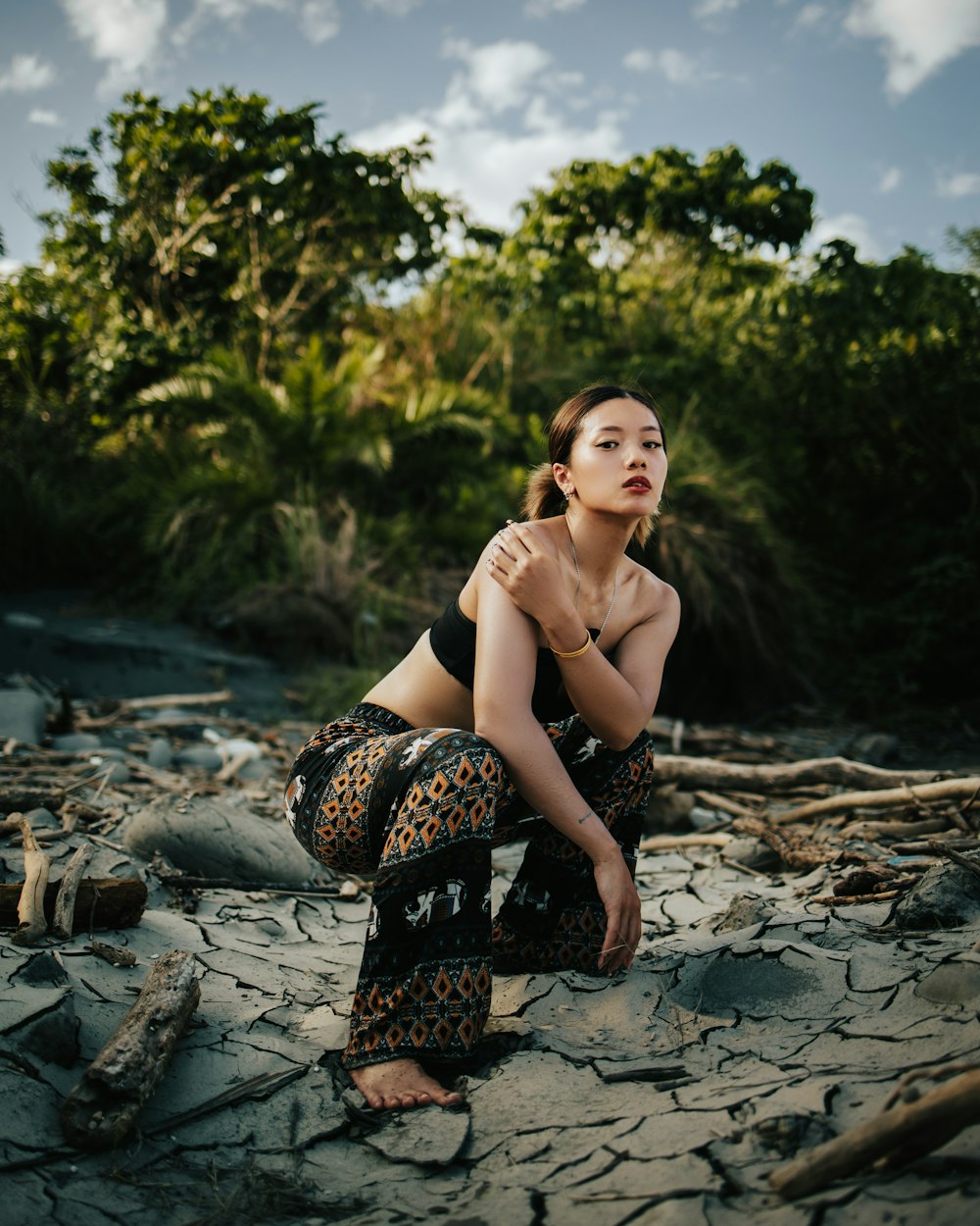 a woman sitting on a rock in the middle of a river