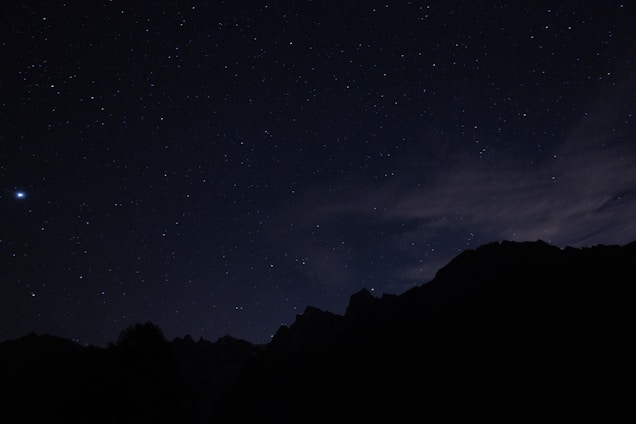 A layered space-themed graphic with mountains and a dark background.