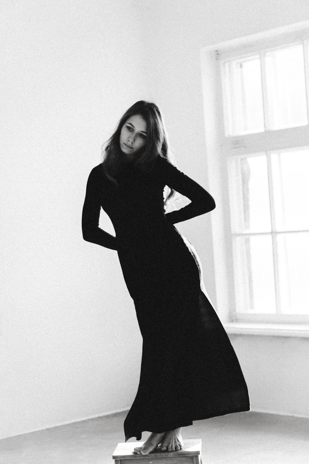 una donna in un lungo abito nero in piedi in una stanza