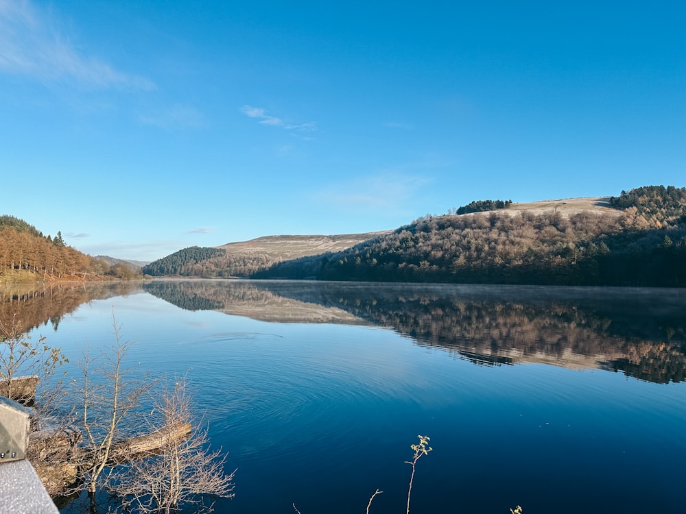 un plan d’eau entouré de montagnes et d’arbres