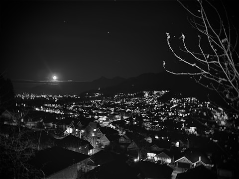 A minimalist black and white photo of a cityscape at night with glowing lights.