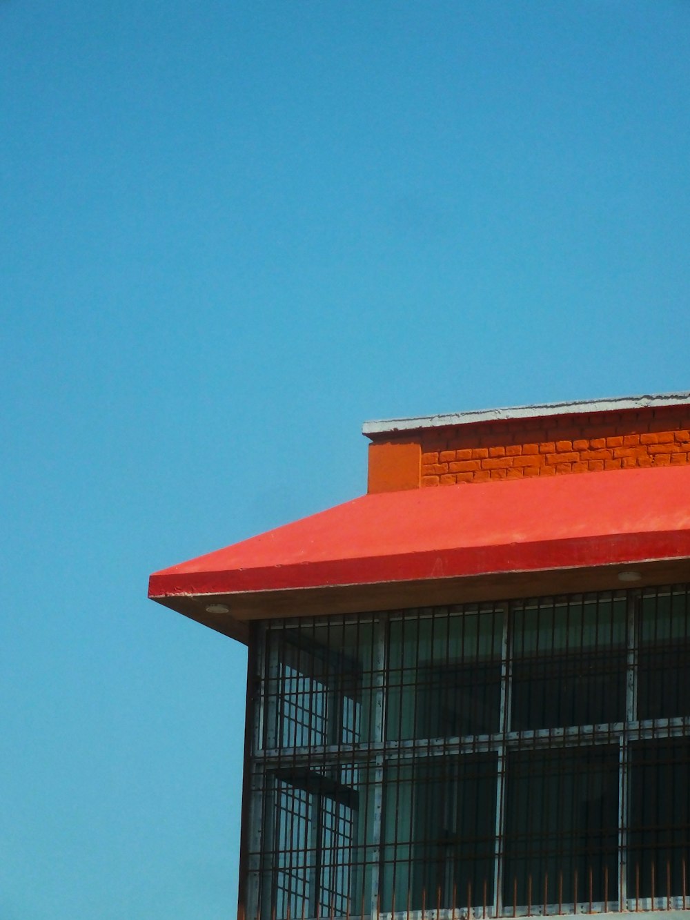an airplane flying over a building with a red roof