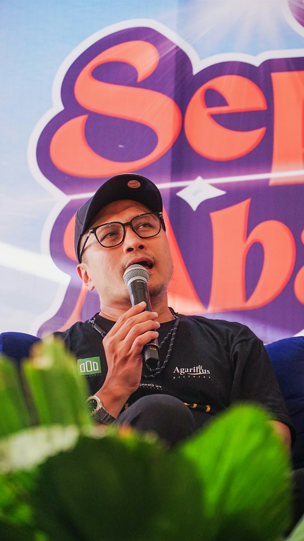 a man sitting in a chair holding a microphone