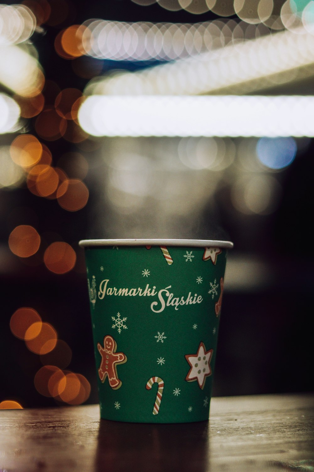 a green cup with a christmas design on it