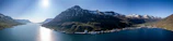 A panoramic view of the fjords in Norway under a clear blue sky