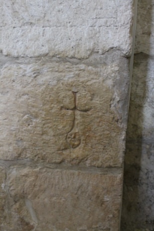 An ancient symbol etched on a weathered stone wall.