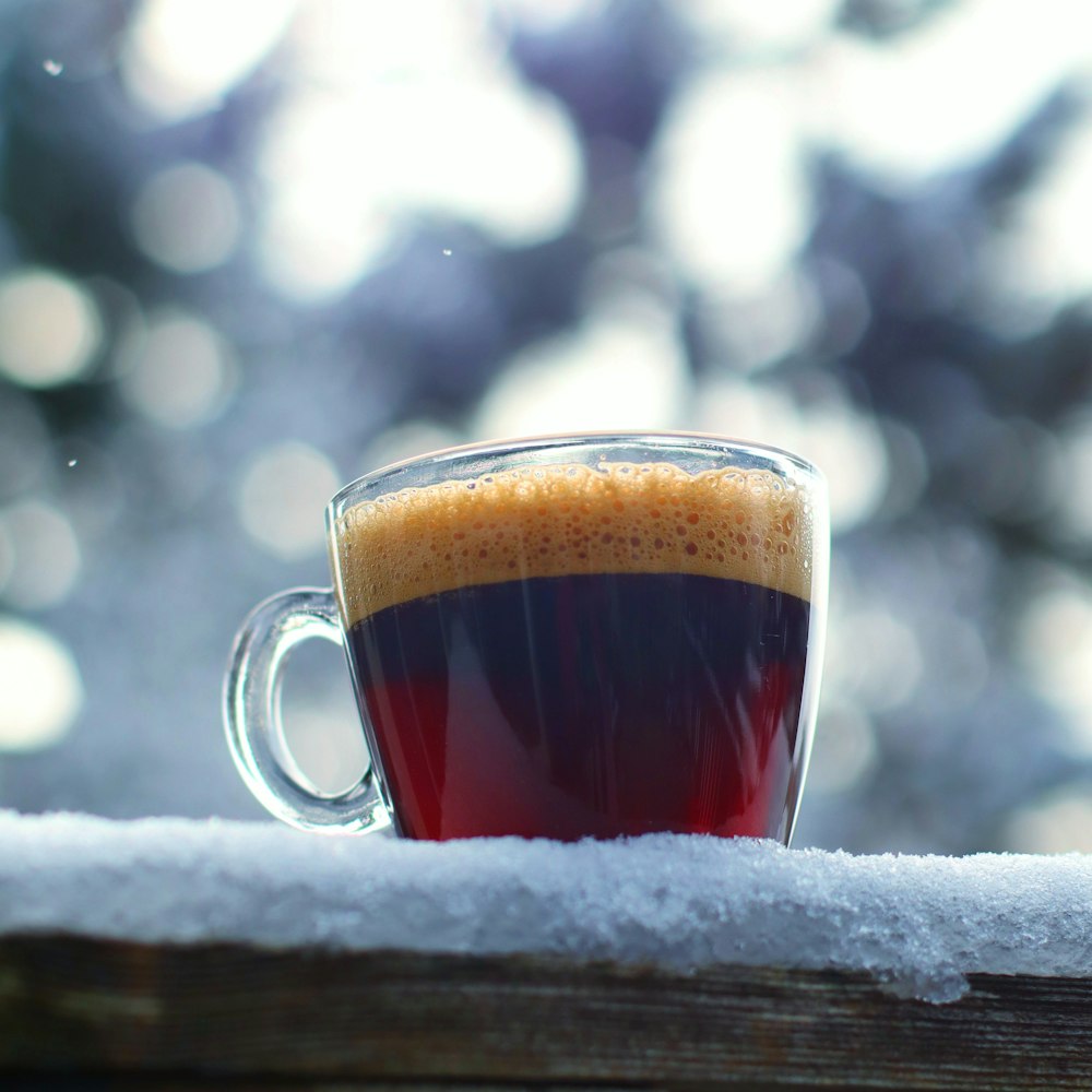 a cup of coffee sitting on top of a wooden table