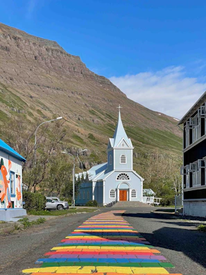 a church with a rainbow painted walkway leading to it