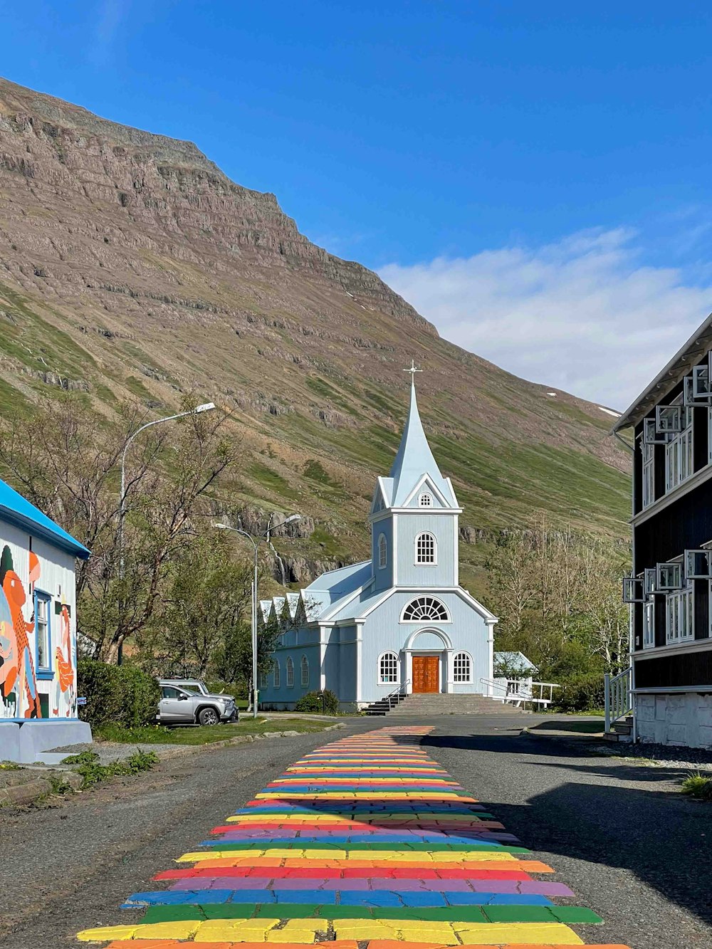 una iglesia con una pasarela pintada de arco iris que conduce a ella
