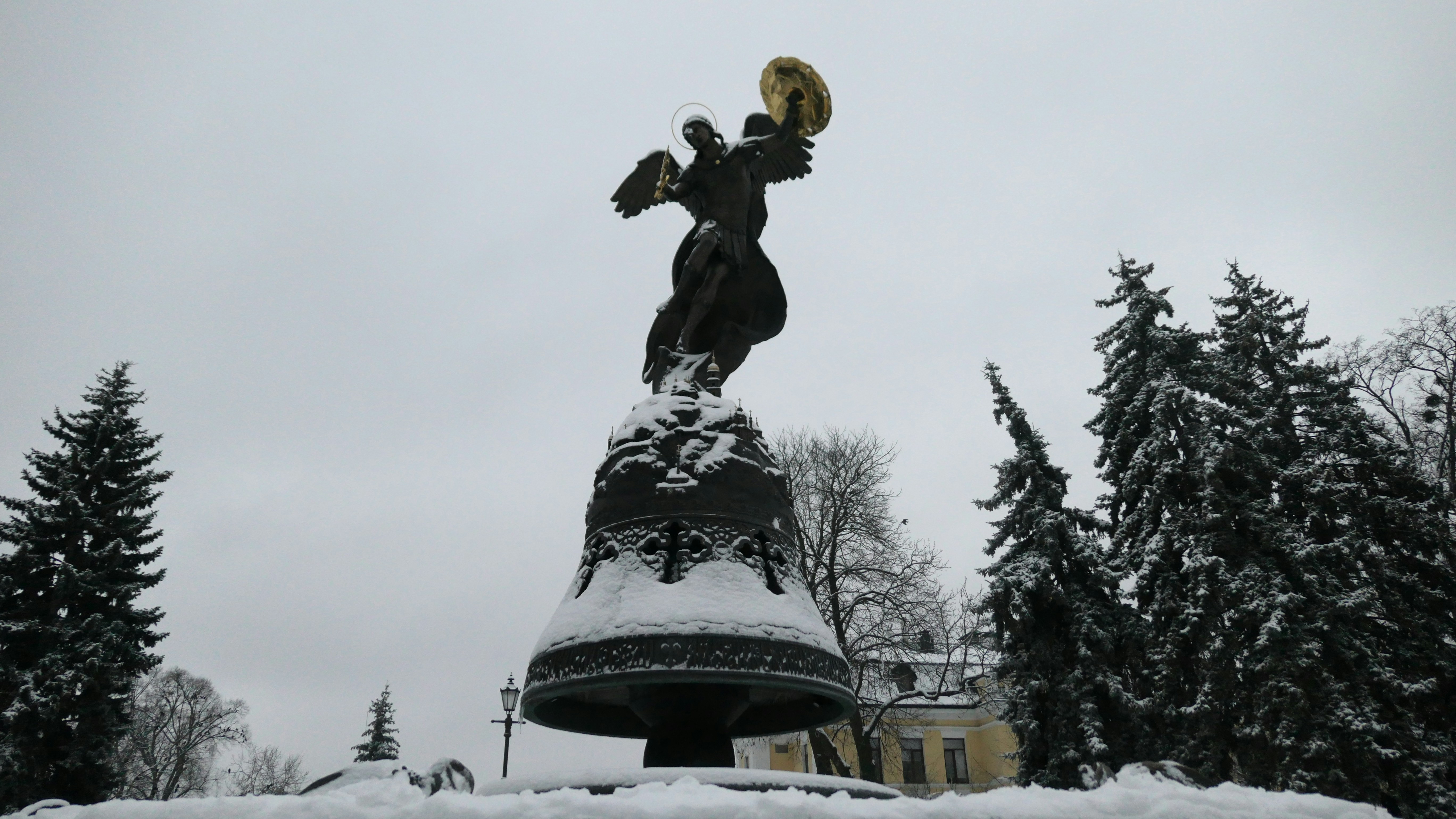 a statue of a woman holding a bird in the snow