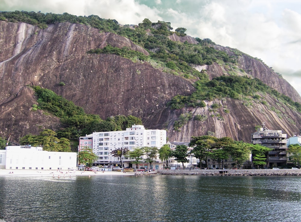 a city on the shore of a lake with a mountain in the background