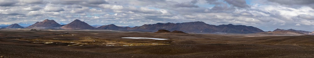 a group of mountains with a cloudy sky