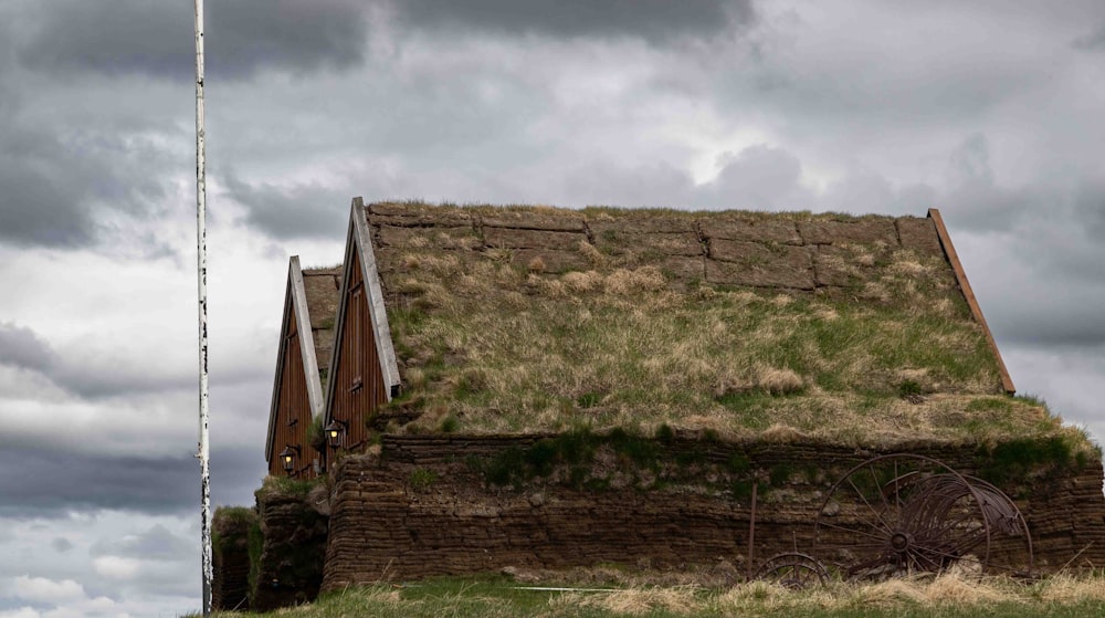 a building with a grass roof and a flag on top of it