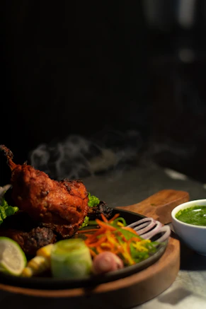 a plate of food on a table with a bowl of sauce