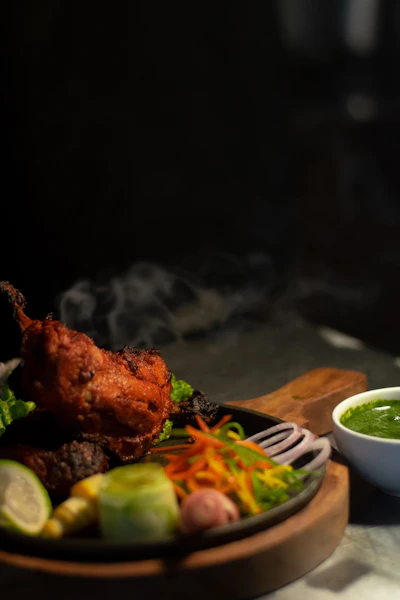 a plate of food on a table with a bowl of sauce