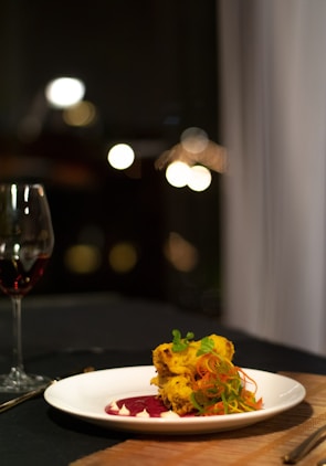 Close-up of a gourmet dish illuminated with dynamic colored lights highlighting textures.