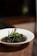 A steaming bowl of chicken curry garnished with fresh herbs on a rustic table.