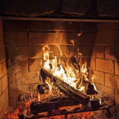 a fire burning inside of a brick fireplace