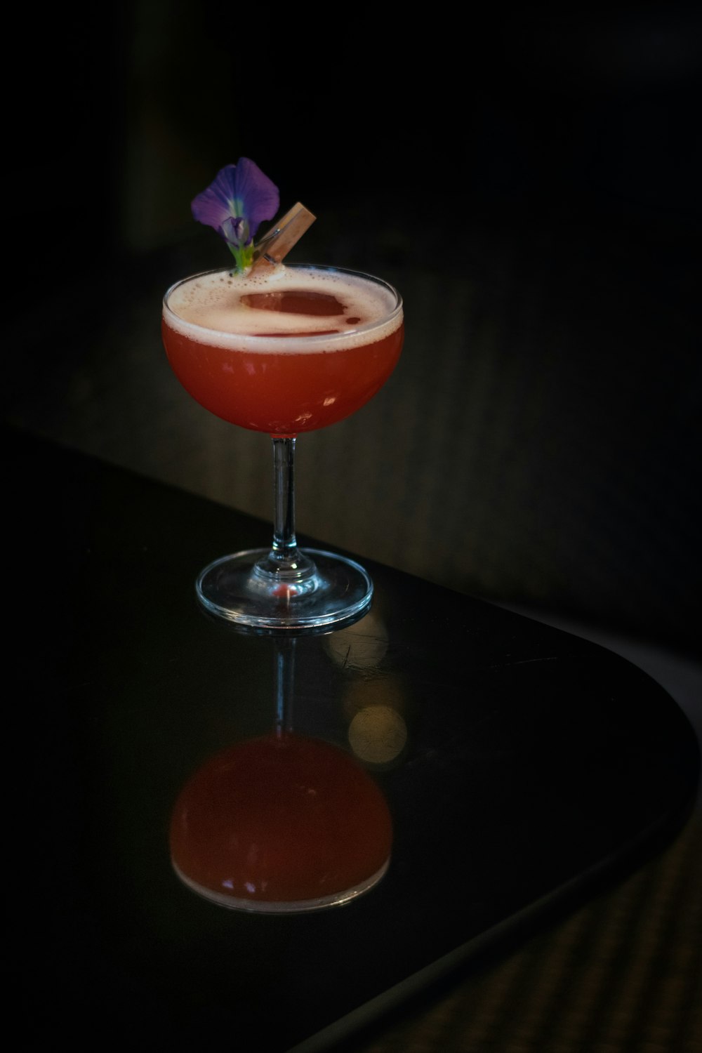 a red drink sitting on top of a black table