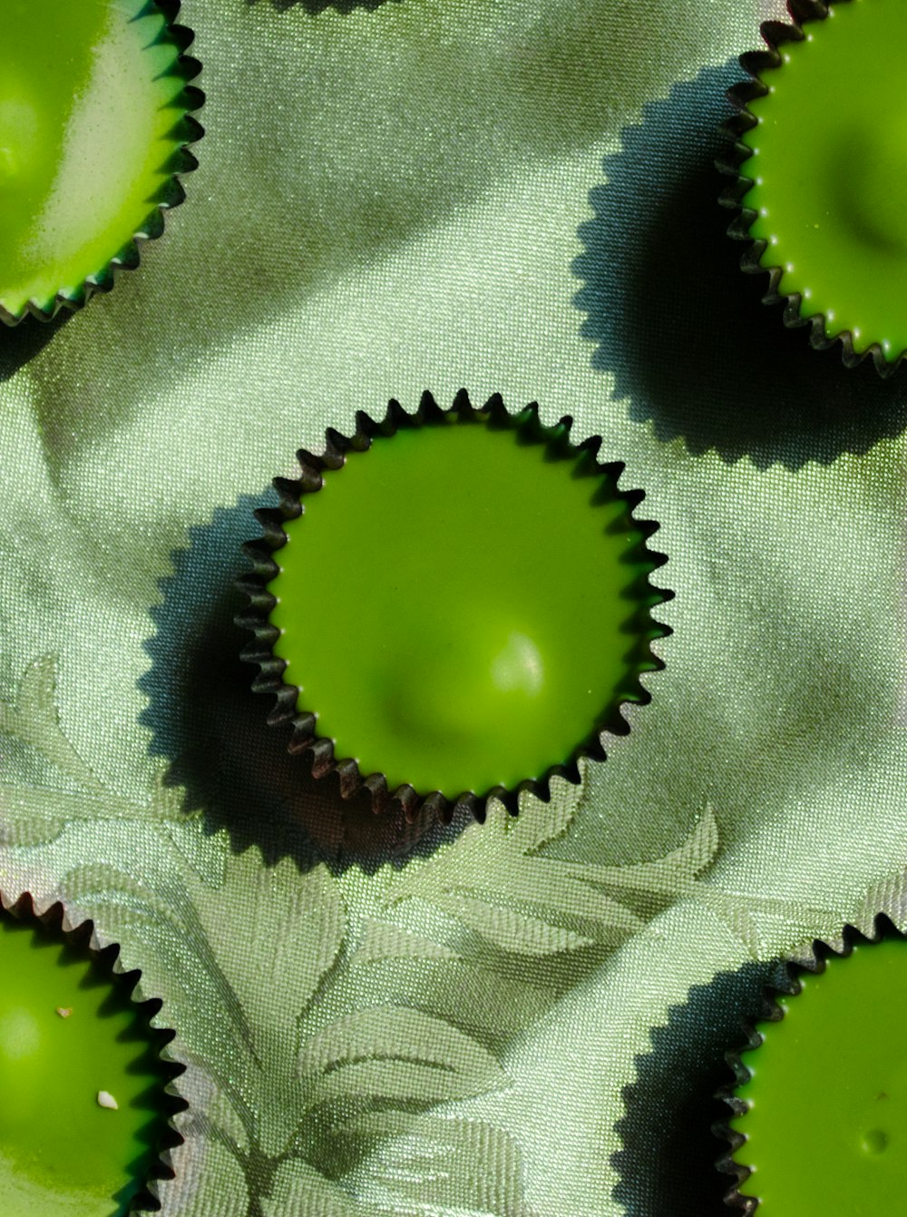 a close up of green cupcakes on a white cloth