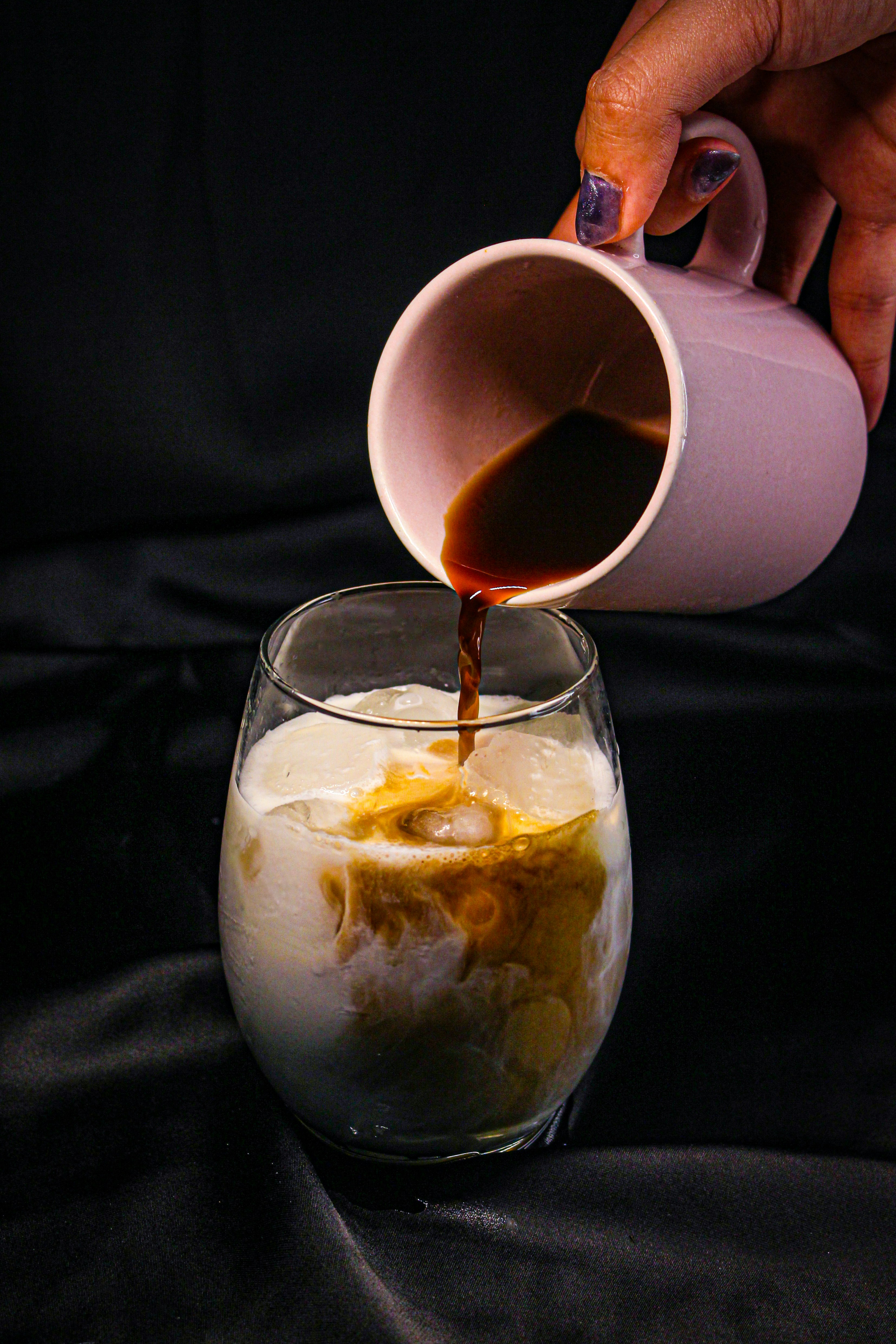 a person pours a drink into a glass