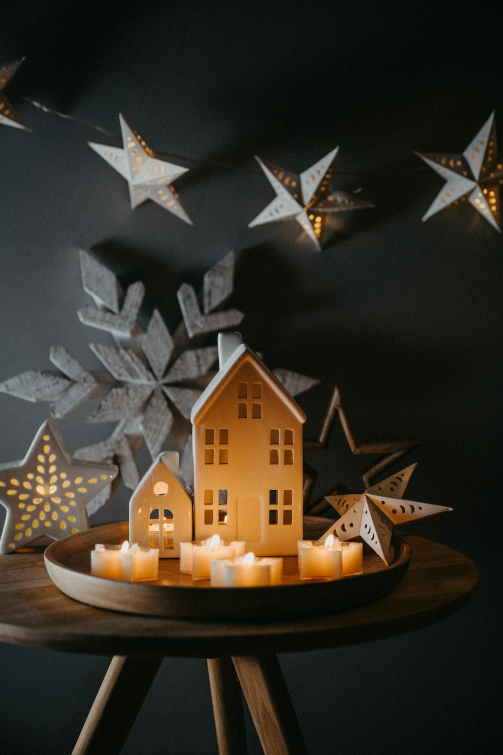 a wooden table topped with a lit up house