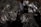 A collection of dark, metallic minerals with shiny surfaces and various angular fragments. The texture appears rough with a mix of reflective and matte areas.