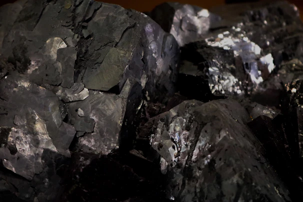 Steel-grey tungsten mineral textures showing metallic luster and rugged surface patterns.