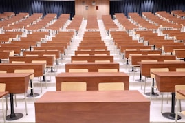 a room filled with lots of wooden desks
