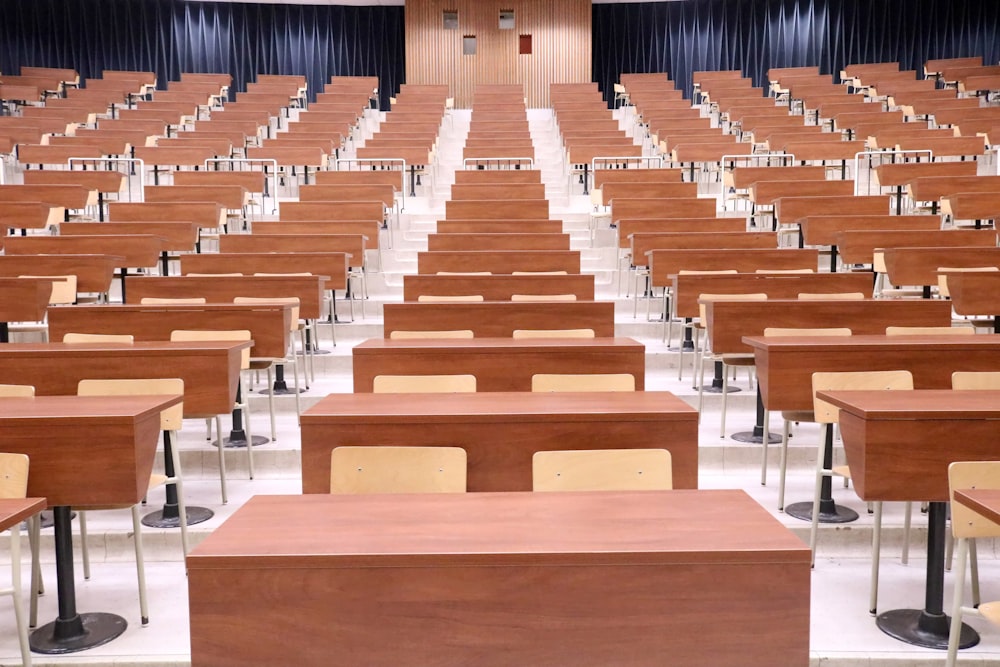 a room filled with lots of wooden desks