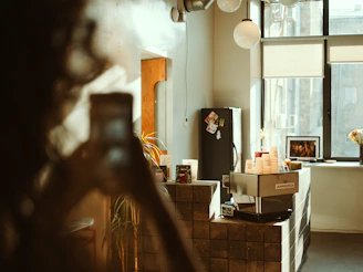 A cozy Scandinavian-style café corner with warm lighting, fresh produce on display, and a team member capturing photos on a camera.