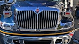 Close-up of the truck’s polished chrome grille and headlights shining in the sunlight.