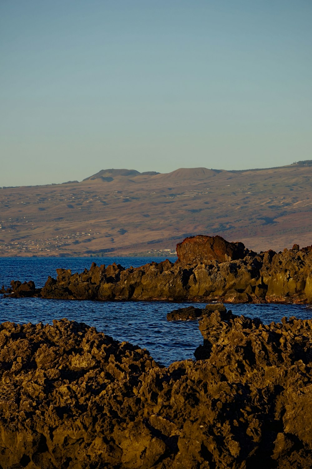 a large body of water sitting next to a rocky shore