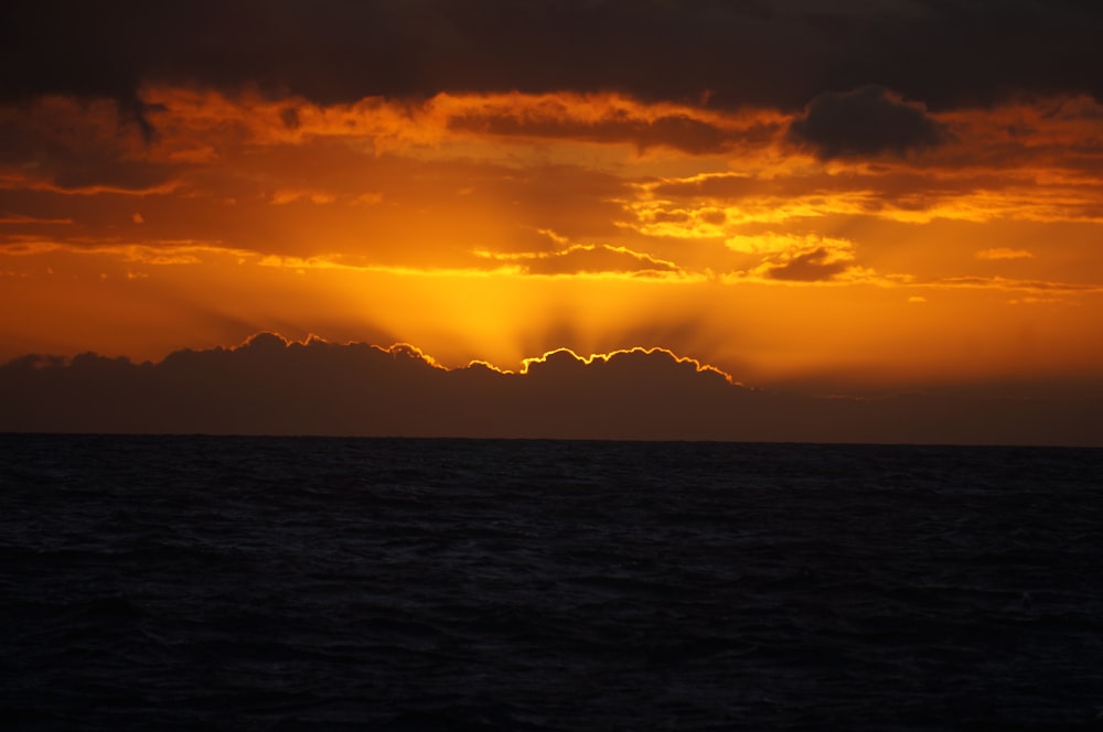 the sun is shining through the clouds over the ocean