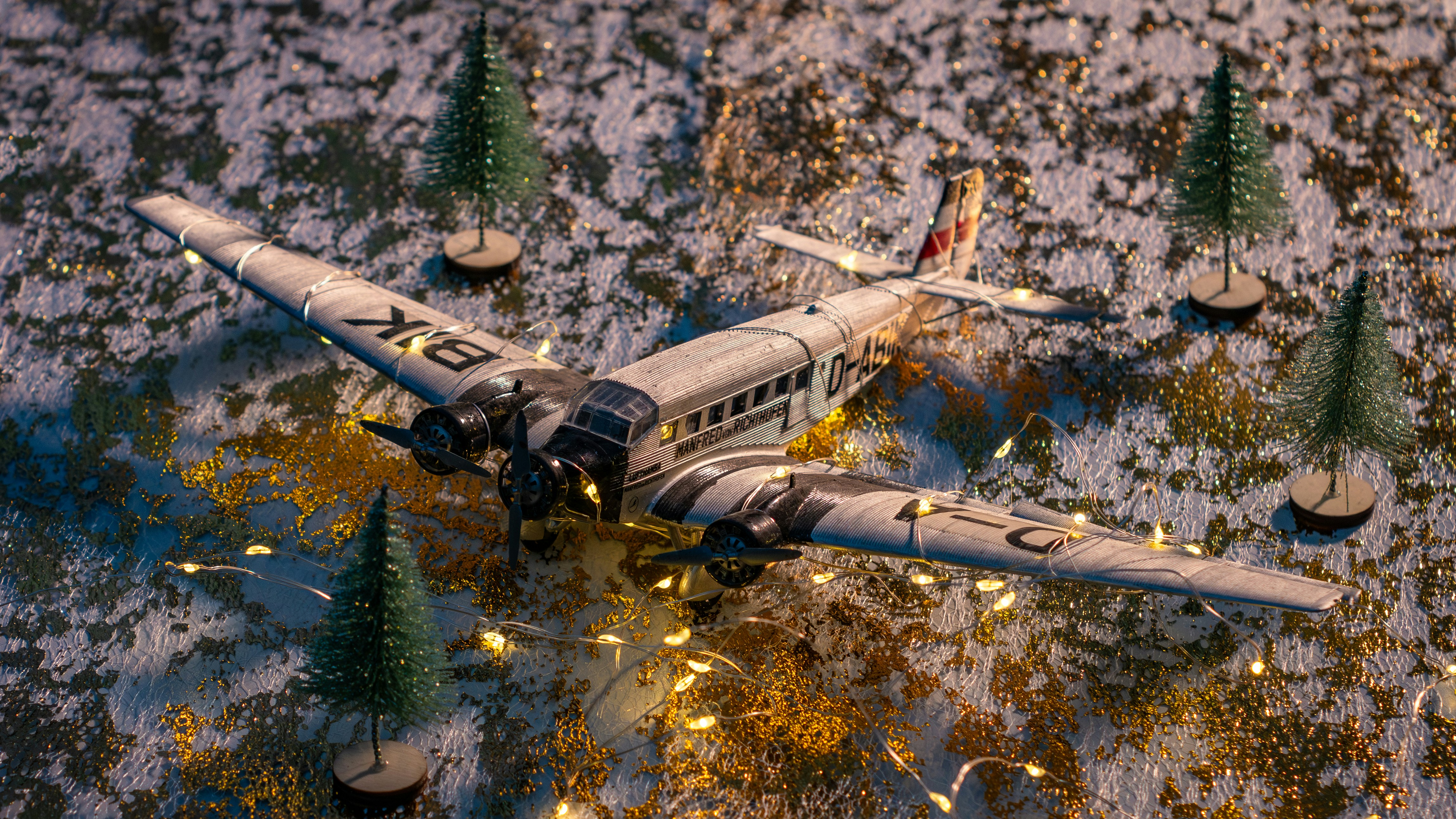 a model airplane is sitting on a snowy surface, My model of the Junkers Ju 52 in a Christmas set