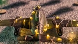 A model airplane wrapped in yellow fairy lights rests on a textured surface, creating a festive and whimsical atmosphere.