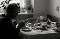 A caregiver assisting an elderly person with daily tasks in a cozy home setting.