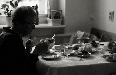 A caring helper assisting an elderly person with daily tasks in a cozy home setting.