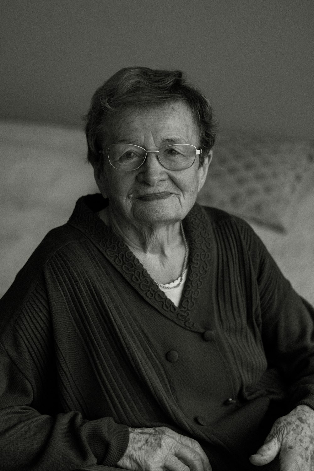 a black and white photo of a woman sitting on a couch