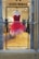 A vibrant red and pink feathered dress displayed on a mannequin inside a high-end fashion boutique. The dress has a heart-shaped neckline and a flamboyant feathered skirt. The background showcases other elegant gowns in various shades, creating a luxurious and sophisticated ambiance.