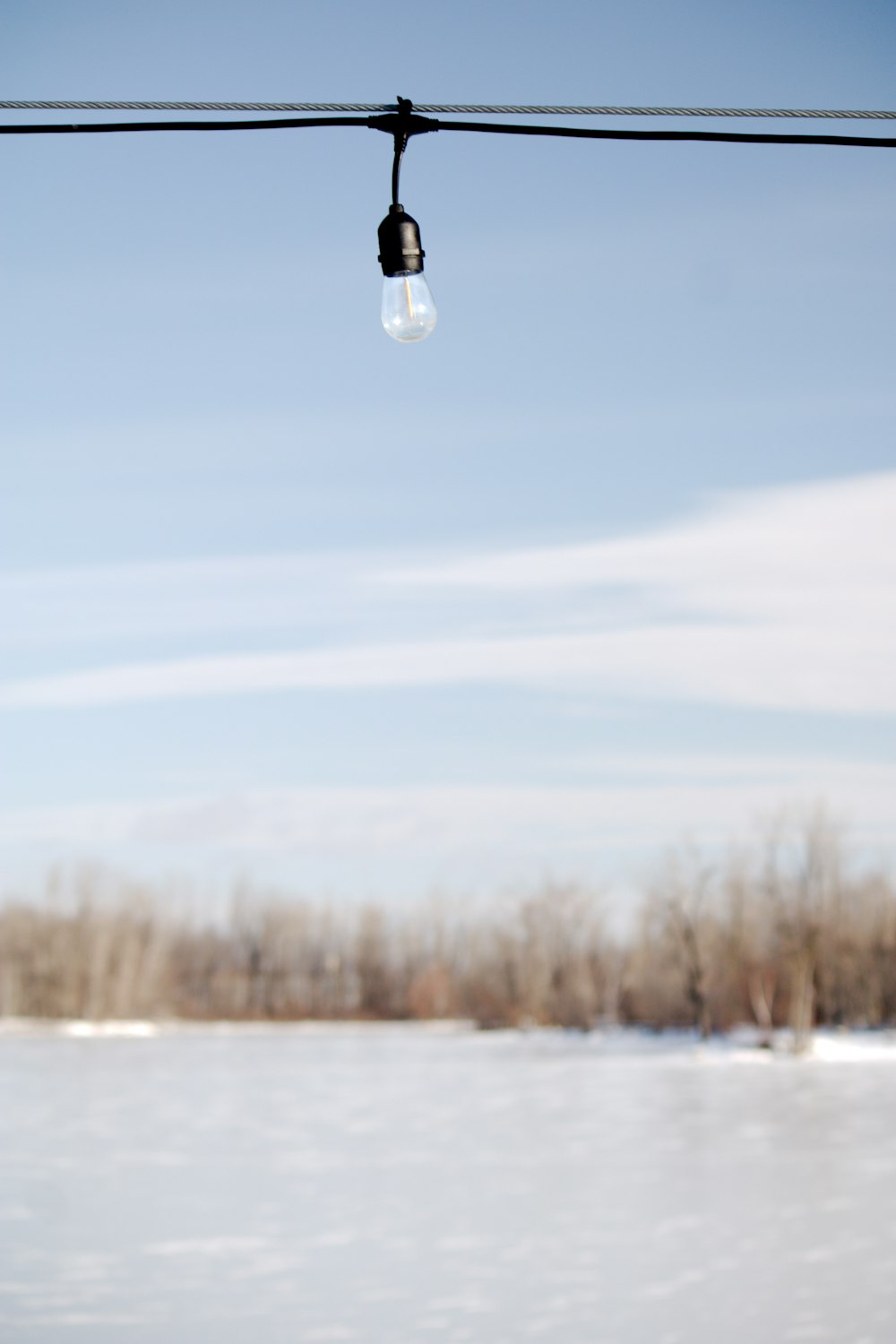 a light that is hanging from a wire in the snow