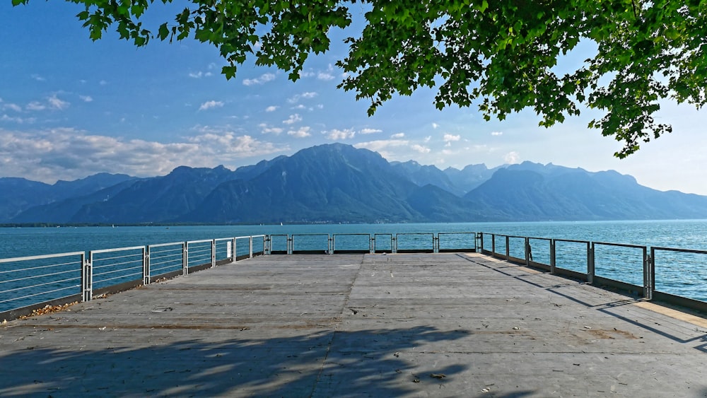 a long pier with mountains in the background