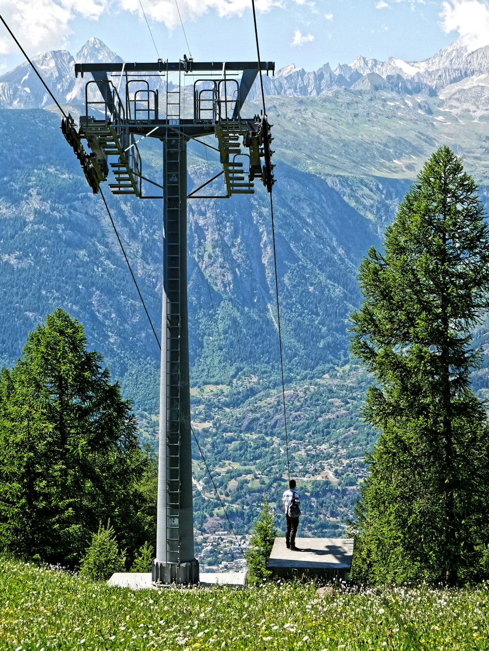 a person standing under a ski lift in the mountains