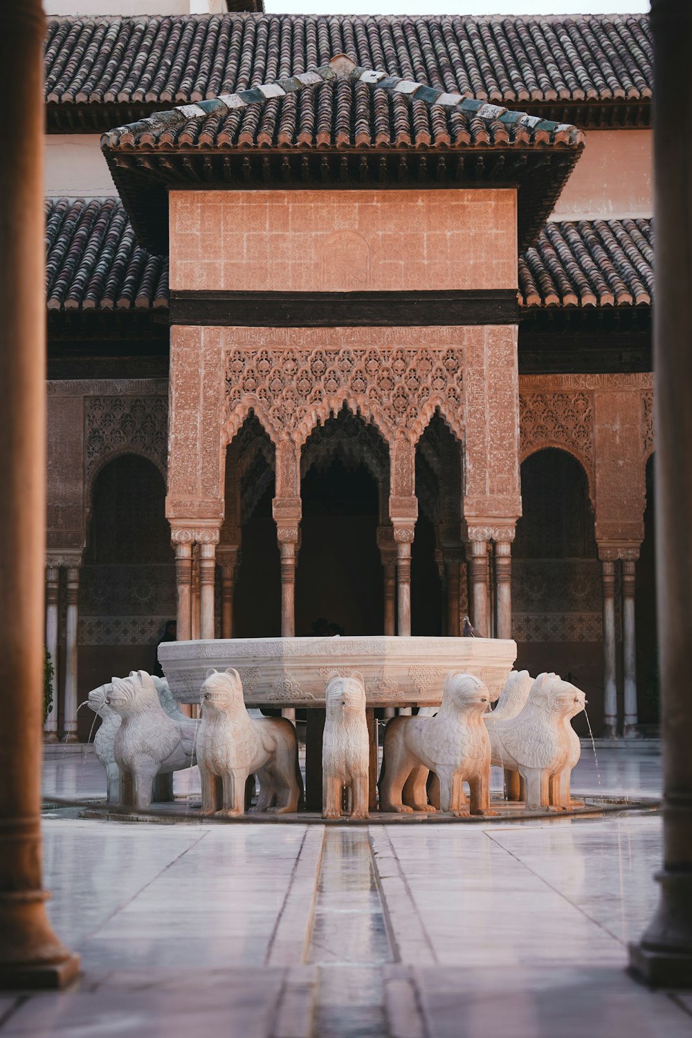 a group of sheep standing in front of a fountain