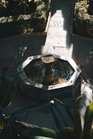 A cozy garden nook with a small water fountain and colorful seasonal flowers.