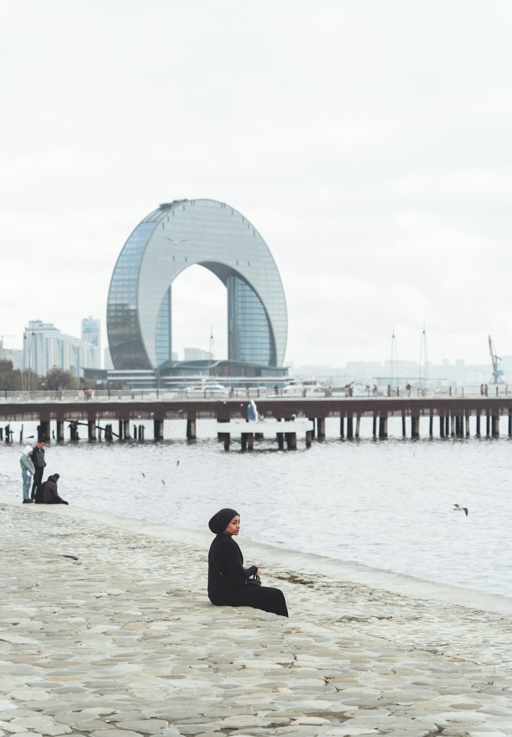 a person sitting on a beach next to a body of water